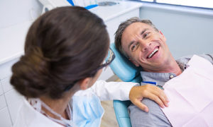 A patient smiling after receiving dental crowns and dental bridge at a San Francisco dentist.