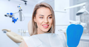 A young woman admiring her healthy teeth and gums thanks to holistic dental care.