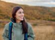 young woman smiling outdoors, natural smile