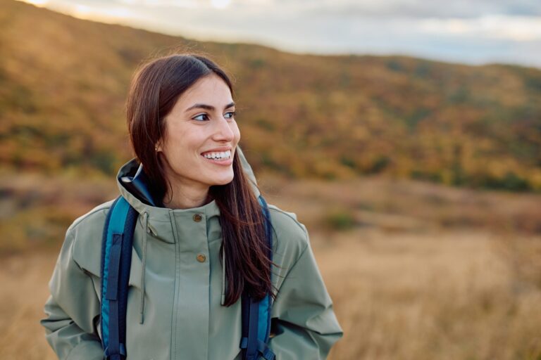 young woman smiling outdoors, natural smile
