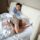 wife gently nudging her snoring husband in bed